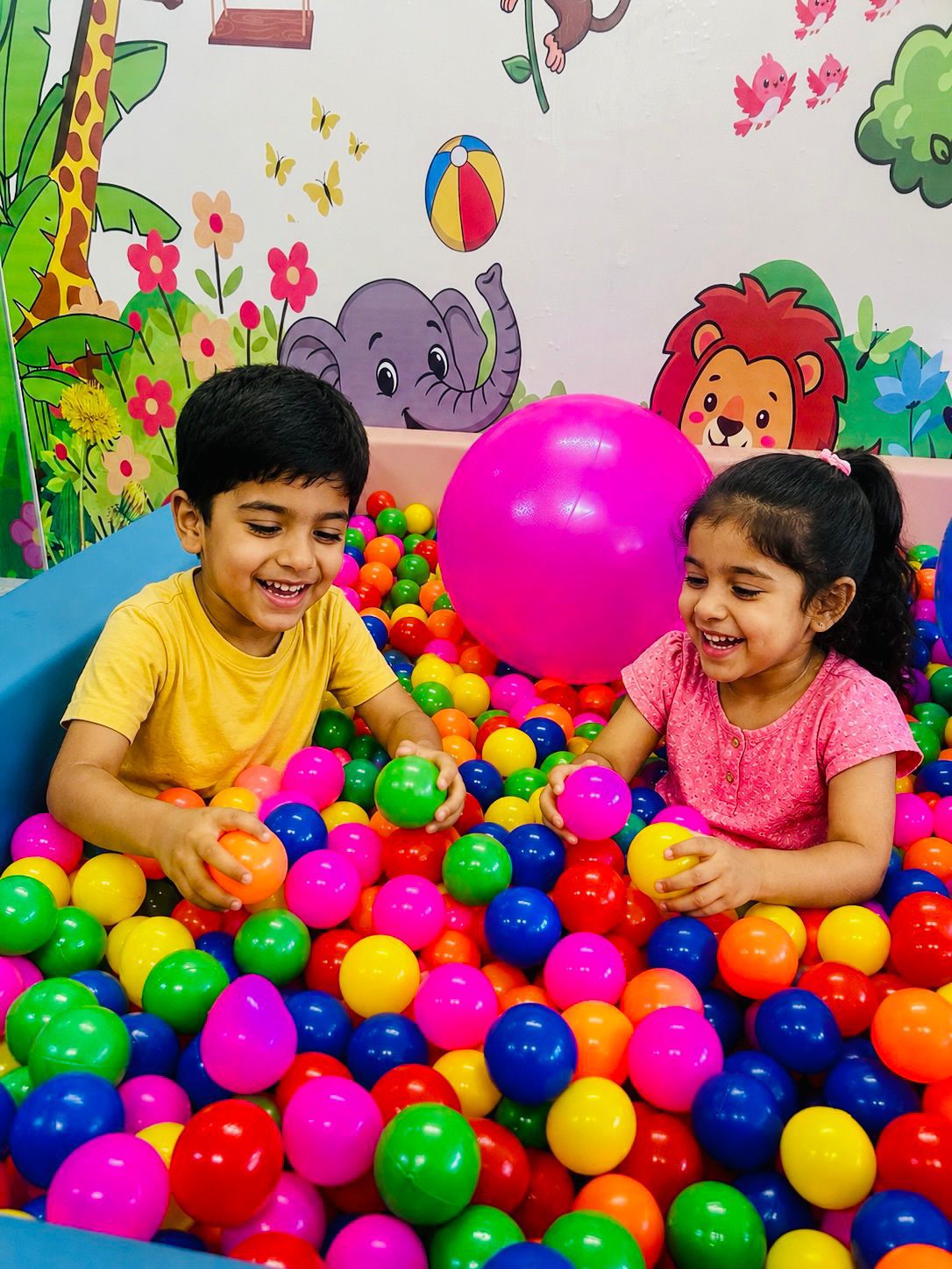 Children enjoying the colorful ball pool at Little Luminaries